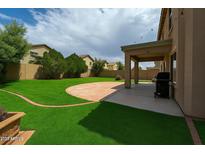 Lush backyard featuring a spacious patio area perfect for outdoor entertaining and relaxation at 44328 W Knauss Dr, Maricopa, AZ 85138