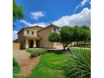 Charming two-story home featuring a landscaped yard, inviting porch, and beautiful curb appeal on a sunny day at 44328 W Knauss Dr, Maricopa, AZ 85138