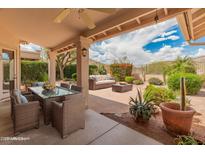Covered patio area with outdoor seating and dining table overlooking professionally landscaped yard at 5936 W Via Montoya Dr, Glendale, AZ 85310