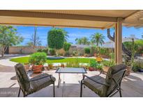 Inviting covered back patio with comfortable seating and a view of the lush green backyard at 6401 N 82Nd Way, Scottsdale, AZ 85250