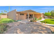 Spacious backyard with covered patio, desert landscaping, and artificial turf at 6401 N 82Nd Way, Scottsdale, AZ 85250