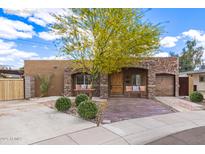 Charming home with stone accents, lush landscaping, and inviting front porch at 7726 E Kimsey Ln, Scottsdale, AZ 85257