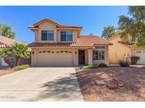 Charming two-story home featuring a desert landscape and a welcoming two car garage at 8845 E Larkspur Dr, Scottsdale, AZ 85260