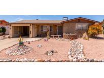 Charming single-story brick home with desert landscaping, rock accents, and a welcoming walkway at 962 S Main Dr, Apache Junction, AZ 85120