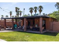 Inviting backyard with a covered patio, outdoor seating, and manicured lawn with mature landscaping, offering a private oasis at 1546 W Culver St, Phoenix, AZ 85007