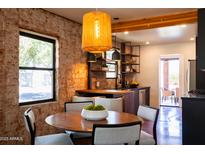 Modern dining area boasts exposed brick, a stylish pendant light, and open-concept kitchen at 1546 W Culver St, Phoenix, AZ 85007