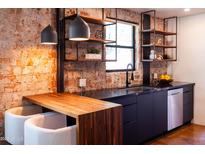 Well-lit kitchen area with dark cabinets, stainless steel appliances and exposed brick at 1546 W Culver St, Phoenix, AZ 85007