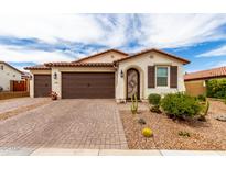 Charming single-story home featuring a three-car garage, desert landscaping, and a decorative front door at 19858 W San Juan Ave, Litchfield Park, AZ 85340