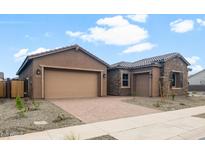 Beautiful home showcasing a well-maintained front yard, a two-car garage, and a stone accent exterior at 22523 E Orchard Ln, Queen Creek, AZ 85142
