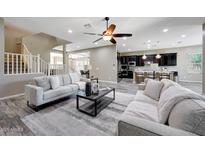 Inviting living room with modern ceiling fan, sleek coffee table, and comfortable seating area at 25449 N 102Nd Dr, Peoria, AZ 85383
