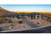 Inviting single-Gathering home with desert landscaping, brick driveway, and a stone-accented entrance in a desirable location at 3135 N Mountainside Loop, Buckeye, AZ 85396