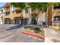 Apartment building exterior featuring well-maintained landscaping, covered parking, and convenient stair access at 5302 E Van Buren St # 2015, Phoenix, AZ 85008