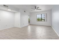 Bright living room showcasing tile flooring, a ceiling fan, and natural light from the window at 5302 E Van Buren St # 2015, Phoenix, AZ 85008