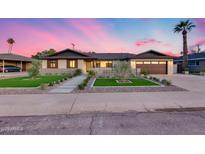 Charming single-story home with an inviting front yard, lush landscaping, and a two-car garage at 8117 E Lewis Ave, Scottsdale, AZ 85257