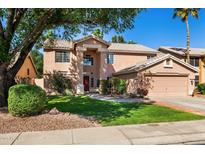 Inviting two-story home features a well-manicured lawn and a charming, classic design at 1381 N Alexis Dr, Gilbert, AZ 85234