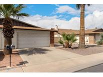 Exterior view of a one story home with a 2-car garage and desert landscaping at 2524 W Kiva Ave, Mesa, AZ 85202