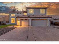 Stunning two-story home featuring a three-car garage and tile roof at sunset at 2754 E Michelle Way, Gilbert, AZ 85234