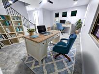 Comfortable home office with a built-in bookcase and a stylish desk with a laptop and a blue chair at 3330 W Gran Paradiso Dr, Phoenix, AZ 85086