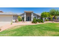 Beautiful single-story home with a lush green lawn and mature desert landscaping at 3544 E Fox St, Mesa, AZ 85213