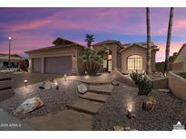 Stunning home featuring desert landscaping, stone pathway, a two-car garage, and vibrant sunset skies at 3797 N 156Th N Dr, Goodyear, AZ 85395
