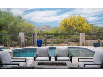 Inviting pool area featuring a sparkling pool, comfortable lounge chairs, and lush desert landscaping with mountain views at 39847 N 105Th Pl, Scottsdale, AZ 85262