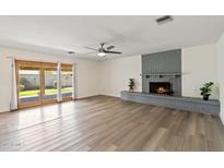 Spacious living room with a cozy brick fireplace and sliding glass doors leading to the outdoor space at 5319 E Gelding Dr, Scottsdale, AZ 85254