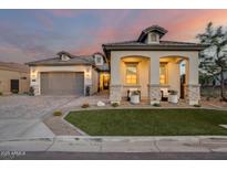Charming single-Gathering home featuring stucco siding, gray accents, three-car garage, and manicured front yard at 5901 E Sierra Morena St, Mesa, AZ 85215