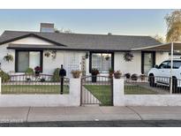 Charming single-story home with a well-manicured front yard, decorative accents, and covered parking in a residential neighborhood at 7943 W Mariposa Dr, Phoenix, AZ 85033