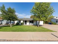 Charming single-story home with a well-maintained lawn and mature trees providing ample shade at 819 N Robson --, Mesa, AZ 85201