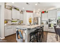 An open kitchen with grey cabinets, granite countertops, an island and stainless steel appliances at 13088 N 91St Dr, Peoria, AZ 85381