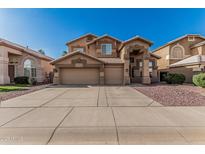 Two-story home featuring a three-car garage, neutral color scheme, desert landscaping, and a concrete driveway at 13750 W Roanoke Ave, Goodyear, AZ 85395