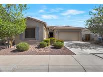 Charming single story home with desert landscaping, tan exterior, and a two car garage at 18023 W Statler St, Surprise, AZ 85388