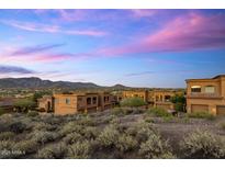 Desert community homes showcase classic architecture against a backdrop of mountains and a colorful sky at 7199 E Ridgeview Pl # 221, Carefree, AZ 85377