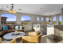 Bright living room featuring arched windows with mountain views, comfortable seating and stylish decor at 7199 E Ridgeview Pl # 221, Carefree, AZ 85377