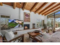 Inviting living room features a fireplace, wood beam ceiling, and comfortable seating at 9154 E Sunflower Ct, Scottsdale, AZ 85266