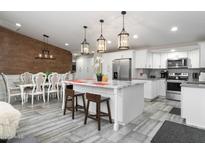 Spacious kitchen with a marble island, stainless steel appliances, and an adjacent dining area featuring wood accent wall at 2025 N 87Th Way, Scottsdale, AZ 85257