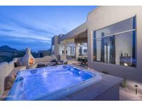 Enjoy the outdoors with the hot tub, fireplace, and seating area on the back patio at 28437 N 112Th Way, Scottsdale, AZ 85262
