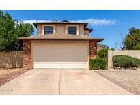Two story home featuring a neutral two car garage, a brick facade, and desert landscaping at 3730 W Michigan Ave, Glendale, AZ 85308