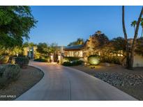 Stunning home exterior featuring a long driveway and beautiful landscape at twilight at 3901 E San Miguel Ave, Paradise Valley, AZ 85253