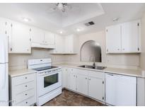 Bright kitchen with white cabinets, appliances, and a neutral countertop offers a clean and functional space at 1217 N Miller Rd # 23, Scottsdale, AZ 85257