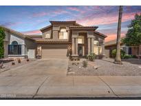 Charming two-story home featuring stucco siding, a two-car garage, desert landscaping, and a tiled roof at 14393 N 101St St, Scottsdale, AZ 85260
