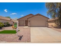 Charming single-story home featuring a neutral color scheme, well-maintained landscaping, and an attached two-car garage at 16274 N 138Th Ln, Surprise, AZ 85374