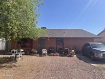 Single story home featuring gravel landscaping and a car in the driveway on a sunny day at 277 W 16Th Ave, Apache Junction, AZ 85120
