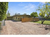 Charming home featuring a brick driveway and a modern horizontal wood fence at 5815 N 10Th Pl, Phoenix, AZ 85014