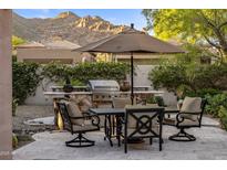 Outdoor patio with stone kitchen, stainless grill, dining table and chairs, with mountain views at 6767 E Nightingale Star Cir, Scottsdale, AZ 85266