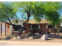 Charming single-story home featuring a desert-landscaped yard and mature trees at 8220 E Montecito Ave, Scottsdale, AZ 85251
