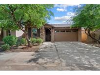 Charming single-story home with a stone facade, well-manicured landscaping, and a two-car garage at 9147 W Minnezona Ave, Phoenix, AZ 85037