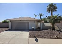 Charming single-story home with a well-maintained landscape, desert rock, and mature trees in the front yard at 9612 N 52Nd Dr, Glendale, AZ 85302