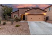Charming stucco home with a two-car garage and desert landscaping at dusk at 10811 W Avenida Del Rey --, Peoria, AZ 85383