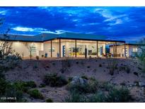Modern, desert home with a flat roof, desert landscaping, and large sliding glass doors at 11426 E Quail Ln, Cave Creek, AZ 85331